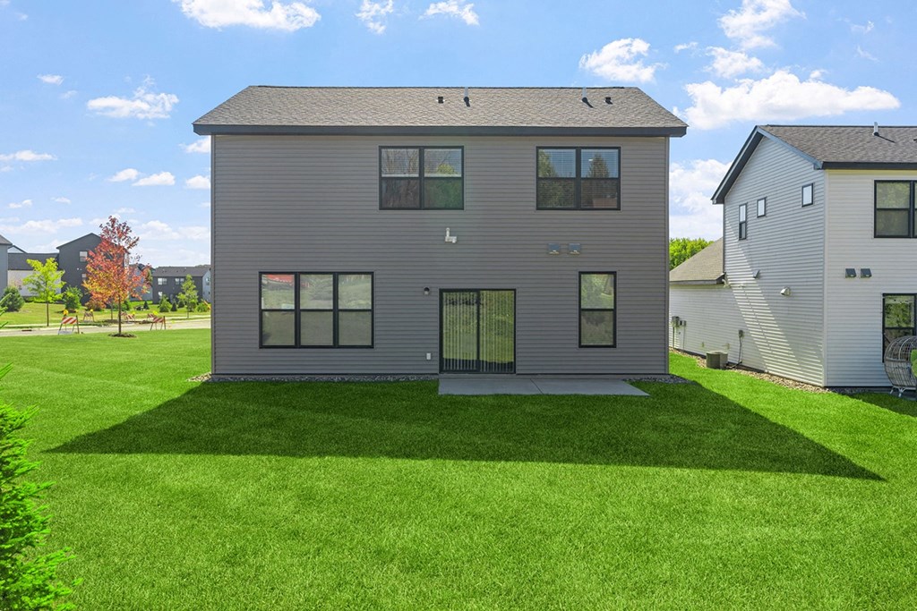 the back of a house with a green lawn