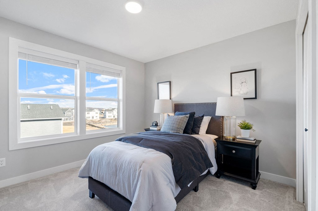 a bedroom with a bed and two windows