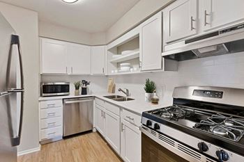 a kitchen with stainless steel appliances and white cabinets