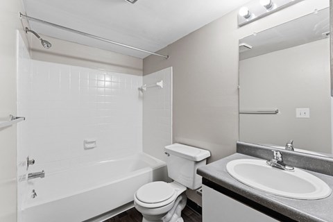 A white bathroom with a toilet, sink, and bathtub.