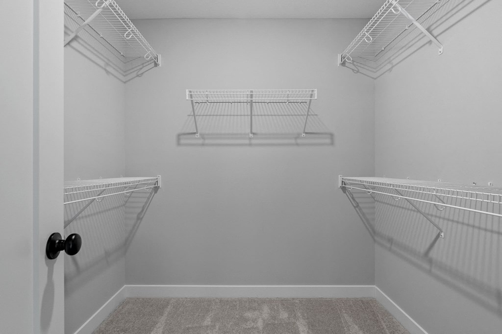 the spacious walk-in closet in the master bedroom of a manufactured home with two hanging closets