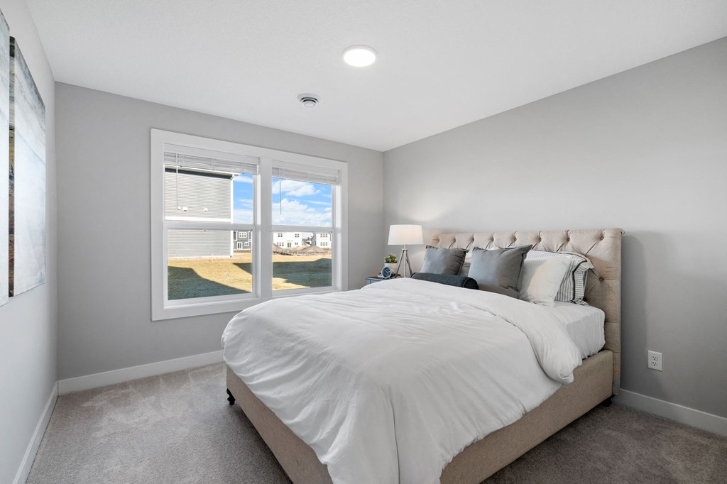 a bedroom with a large bed and a window