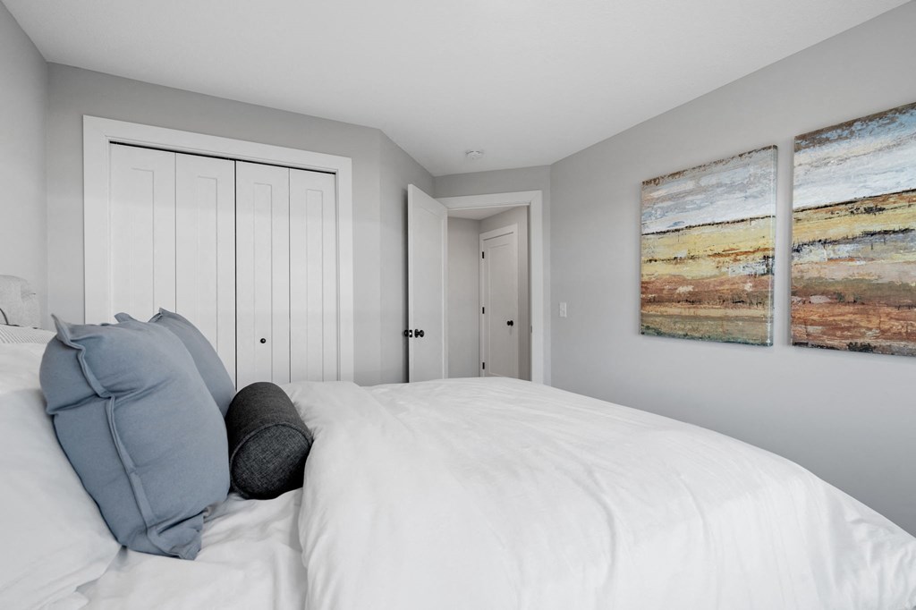a bedroom with a large bed and two paintings on the wall