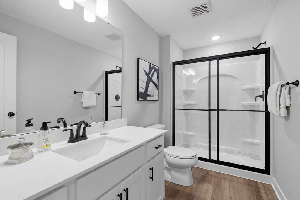 a white bathroom with a shower and a sink and a toilet