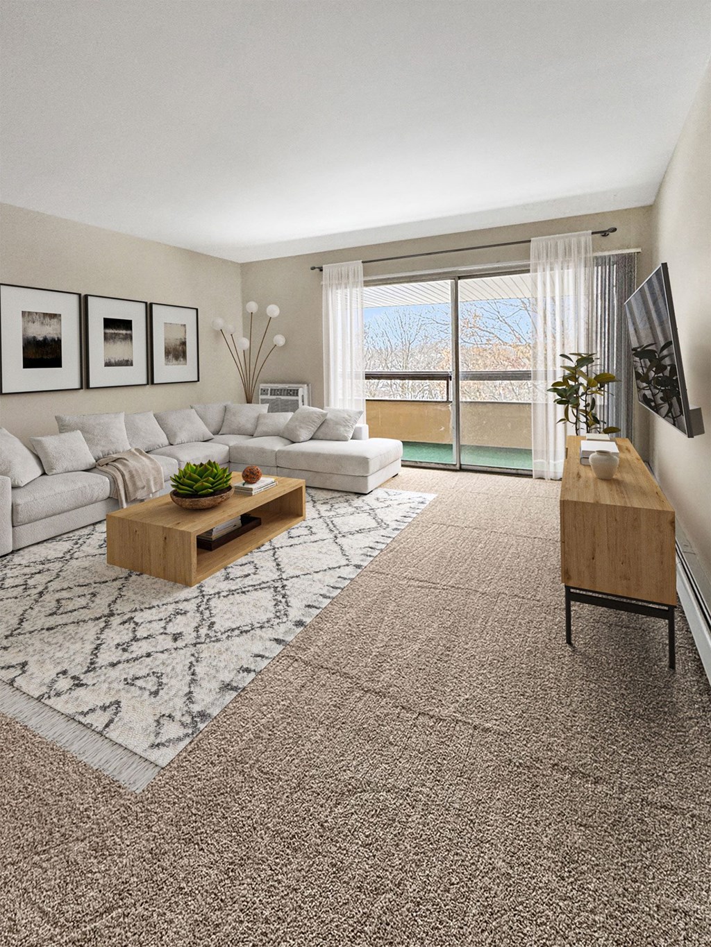 A living room with a white couch, a wooden coffee table, and a flat screen TV mounted on the wall.