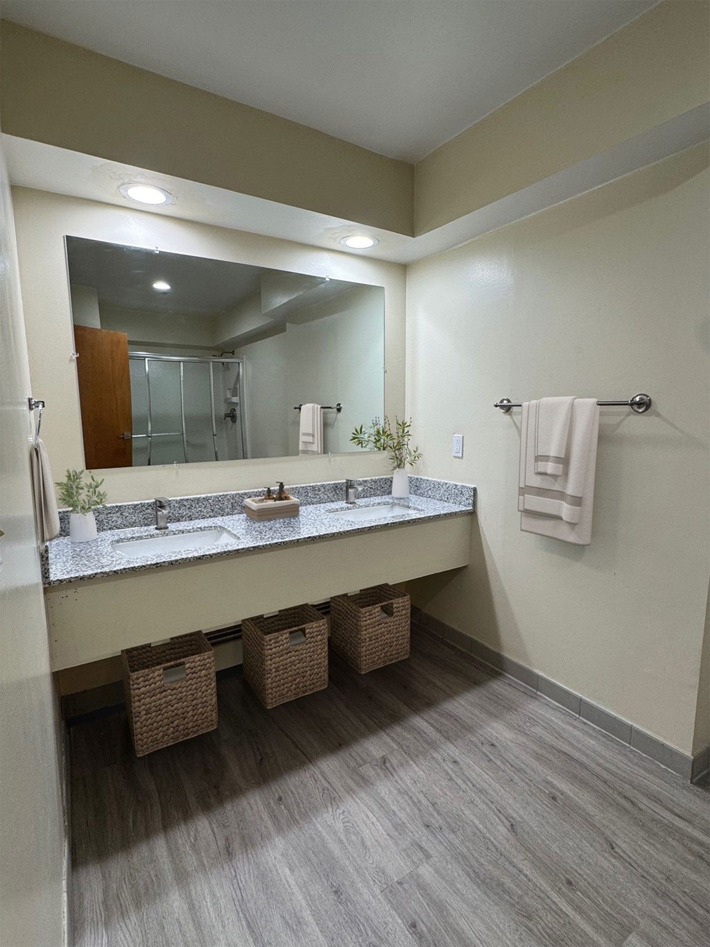 A bathroom with a vanity, mirror, and baskets.