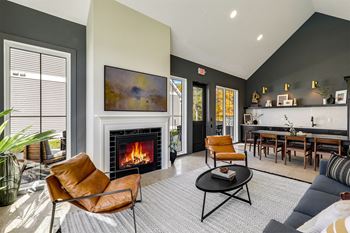 a living room with a fireplace and a table and chairs