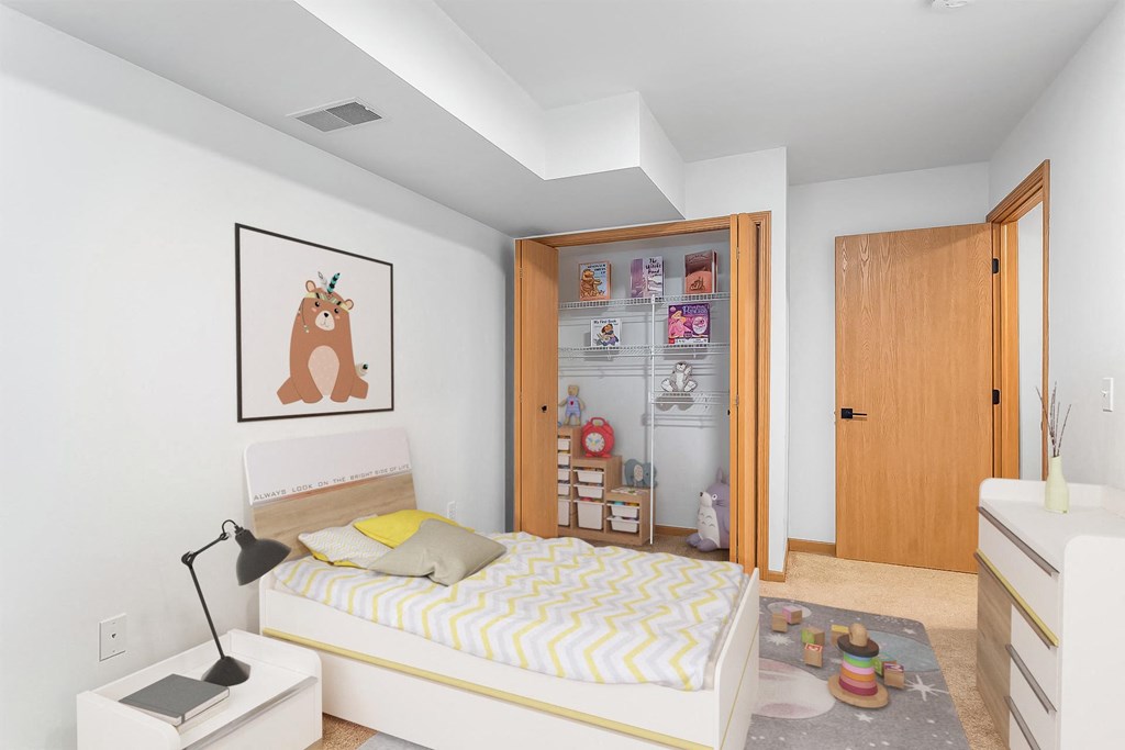 A bedroom with a bed, nightstand, and a picture of a giraffe on the wall.