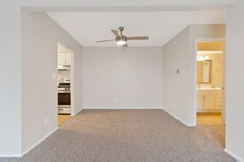 an empty living room with a ceiling fan