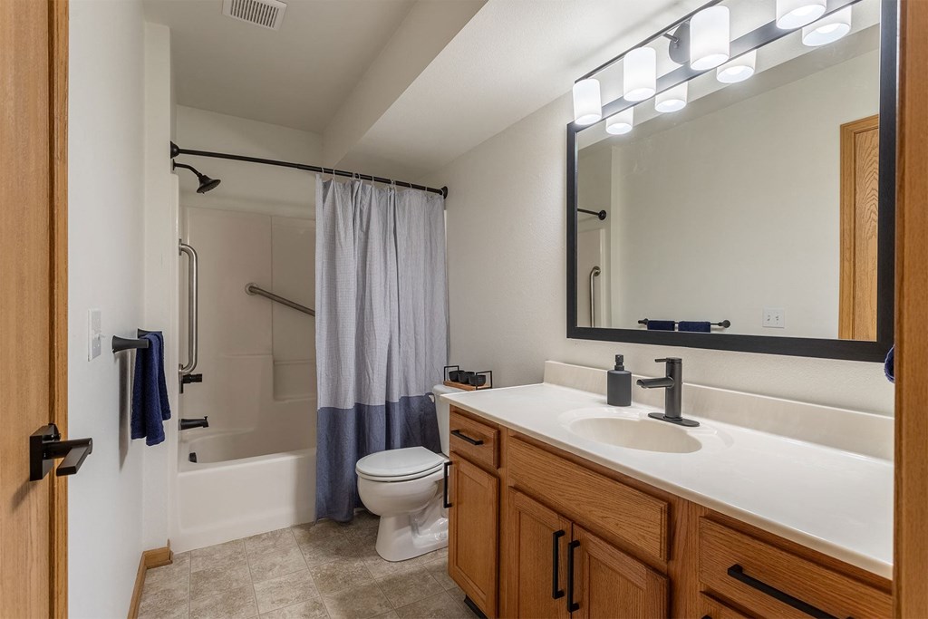 A bathroom with a toilet, sink, and shower.
