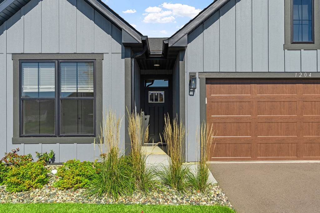 the front of a house with a garage door and