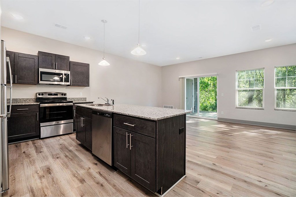 A kitchen with dark wood cabinets and a white countertop.