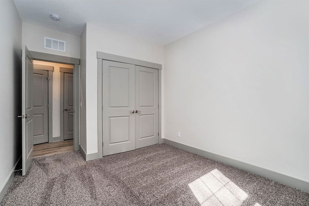 A room with a carpeted floor and a small window.