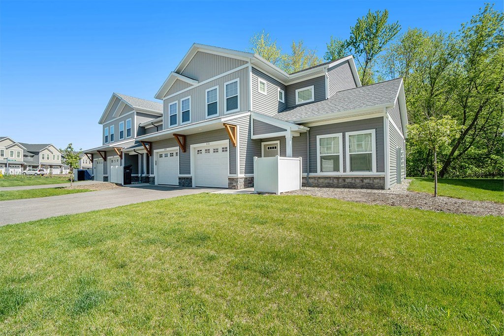 A large, modern house with a spacious front yard.