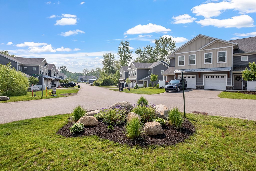 A residential area with houses and a landscaped garden in the foreground.