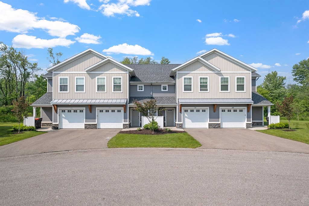 A large house with a grey roof and a grey garage door.