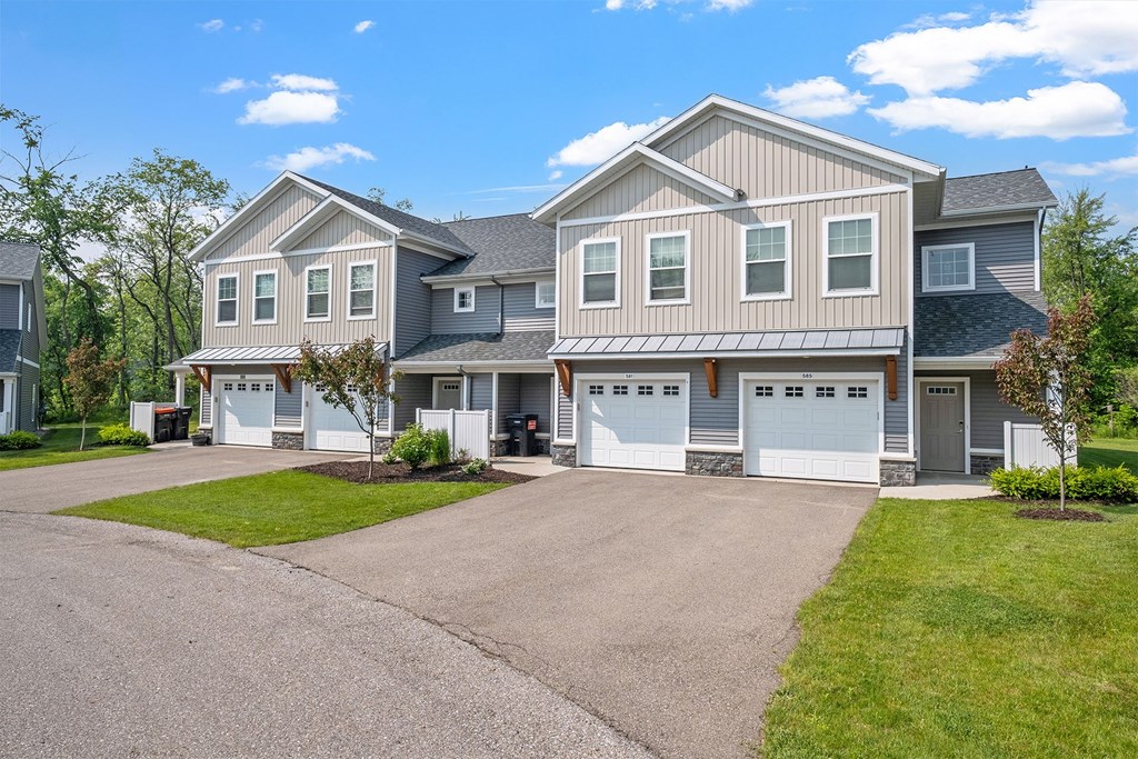 A large house with a grey roof and a grey garage door.