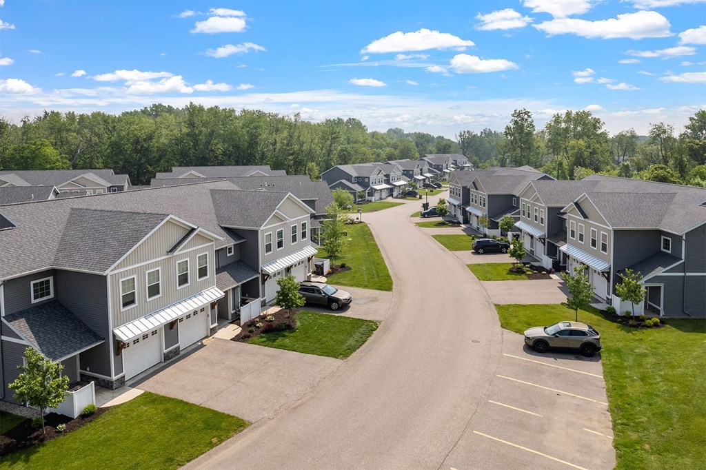 A residential area with houses and a car parked in the driveway.
