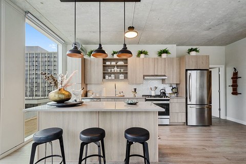 a kitchen with a large island with three stools