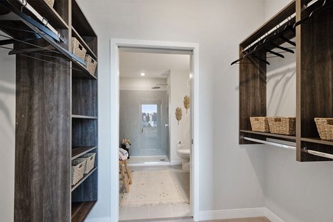 a walk in closet in a bathroom with a toilet