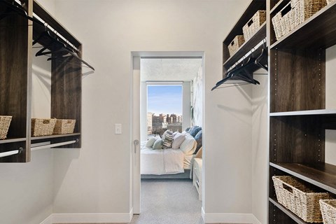 a walk in closet with a view of a living room