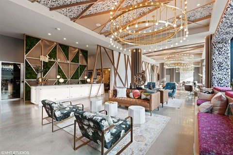 the lobby or reception area of an apartment property with couches and chairs