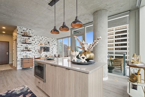 a kitchen with a large island and a large window that leads to balcony