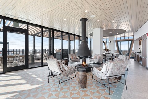apartment lounge area with indoor fire pits and view of the skyline