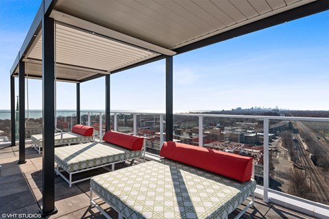 a roof deck with beds and a view of the city