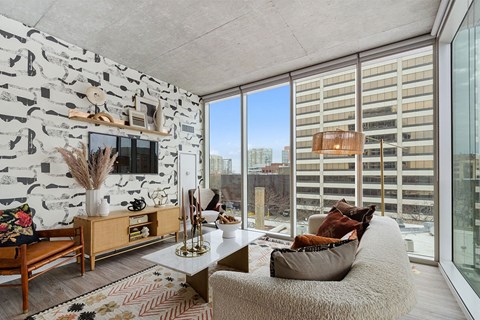 a living room with large windows and a couch and a table