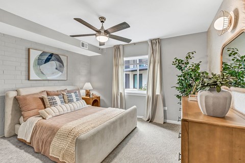 a bedroom with a bed and a ceiling fan