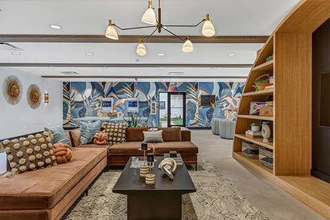 a living room with couches and a coffee table in front of a wall mural