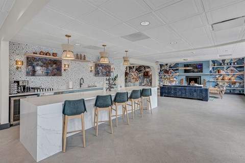the bar area of a restaurant with blue bar stools