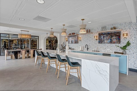 the bar area of a restaurant with blue chairs