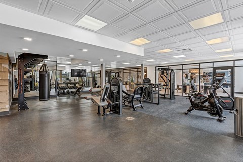 a gym with weights and exercise equipment in a building with glass doors