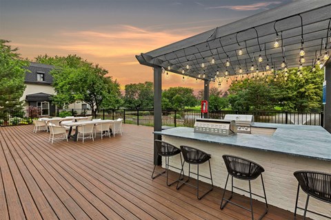 a patio with a bar and tables and chairs