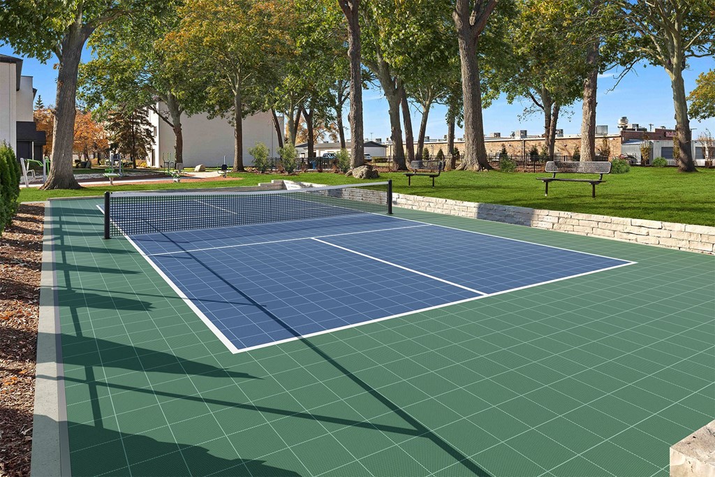 a tennis court in a park with trees
