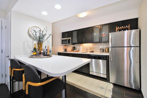 a kitchen with stainless steel appliances and a white countertop island