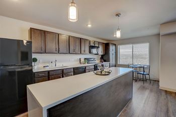 a kitchen with a large island and a stainless steel refrigerator