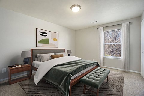 A bedroom with a bed, nightstand, and a painting on the wall.