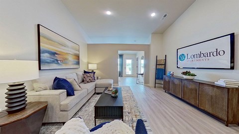 A spacious living room with a couch, coffee table, and a painting on the wall.