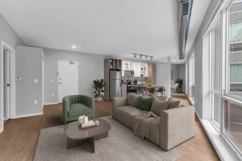 A living room with a green armchair and a grey sofa.