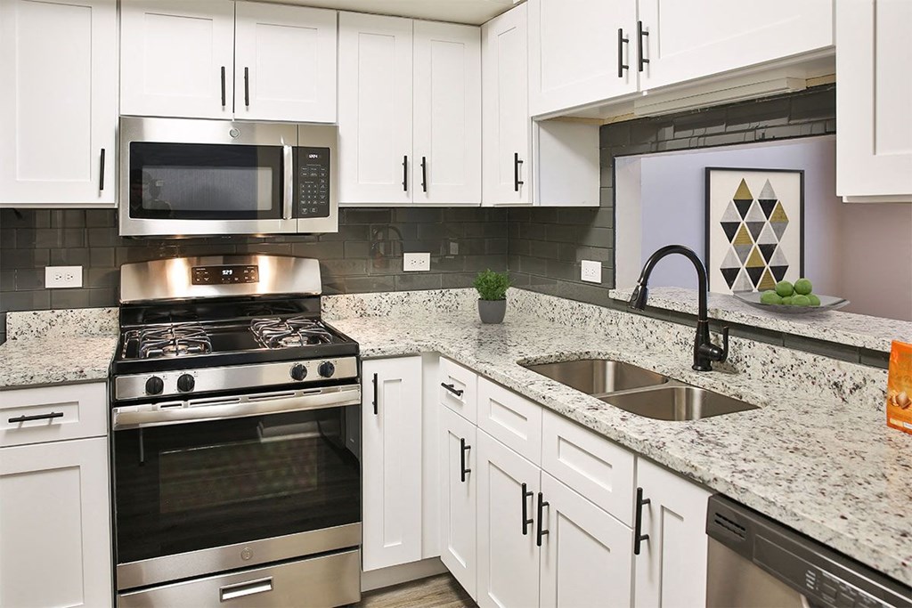 a kitchen with white cabinets and black appliances