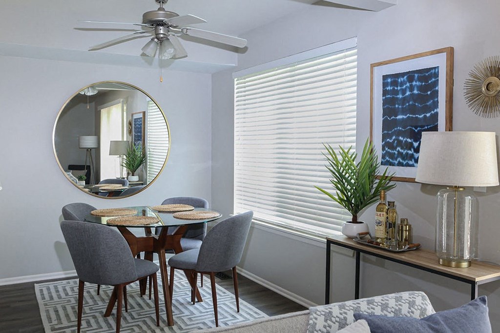 a dining room with a round table and a ceiling fan