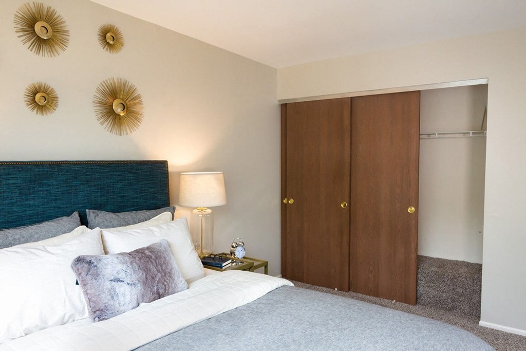 a bedroom with a bed and two closet doors