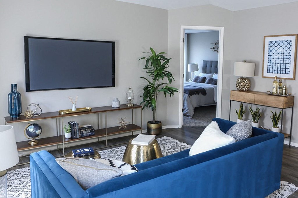 a living room with a blue couch and a tv