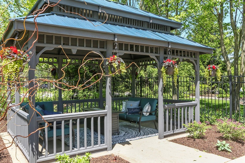 a gazebo with a couch and chairs on it