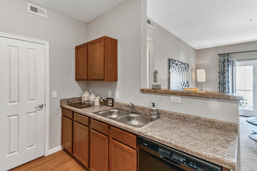 A kitchen with brown cabinets and a granite countertop.