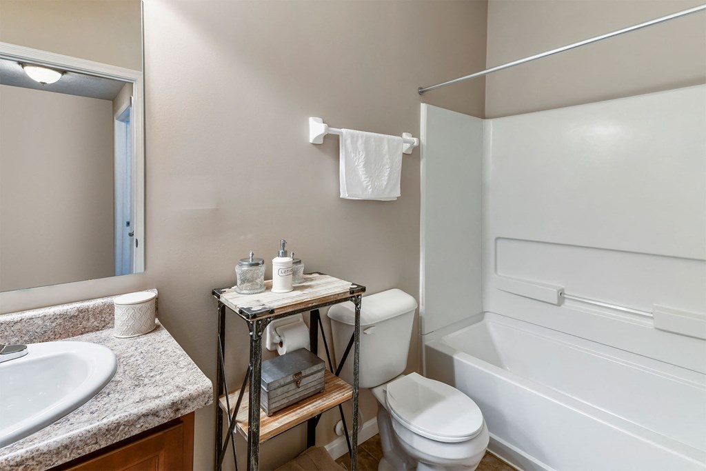 A bathroom with a white toilet, sink, and bathtub.