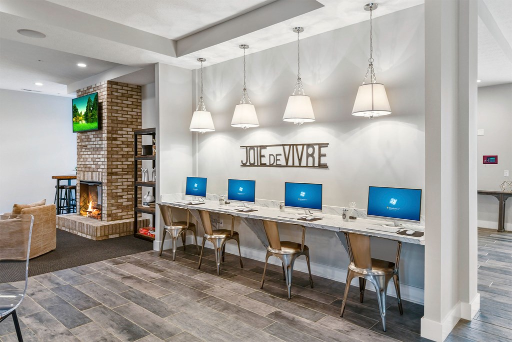 A modern office space with a fireplace and a TV mounted on the wall.